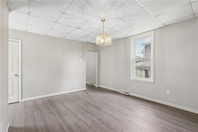 1017 Main St, Coraopolis, PA 15108 - unfurnished room with wood finished floors, a drop ceiling, a chandelier, and baseboards