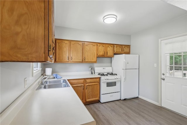 1017 Main St, Coraopolis, PA 15108 - kitchen with white appliances, a sink, light countertops, light wood-type flooring, and brown cabinetry