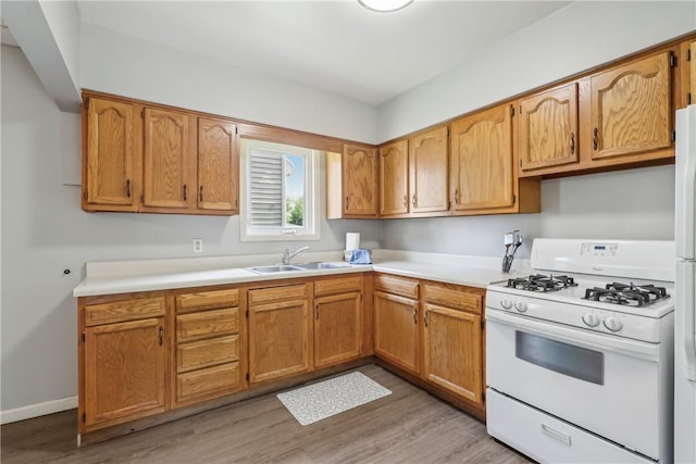 1017 Main St, Coraopolis, PA 15108 - kitchen with white appliances, a sink, light wood-style flooring, and light countertops