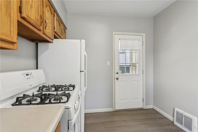 1017 Main St, Coraopolis, PA 15108 - kitchen with white gas range, wood finished floors, brown cabinets, light countertops, and baseboards