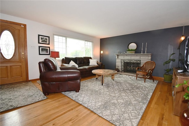 5005 Brownsville Rd, Whitehall, PA 15236 - living area featuring light wood-style flooring, a stone fireplace, and baseboards