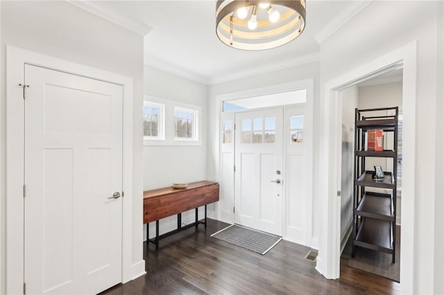 foyer with dark wood-style floors, crown molding, and baseboards