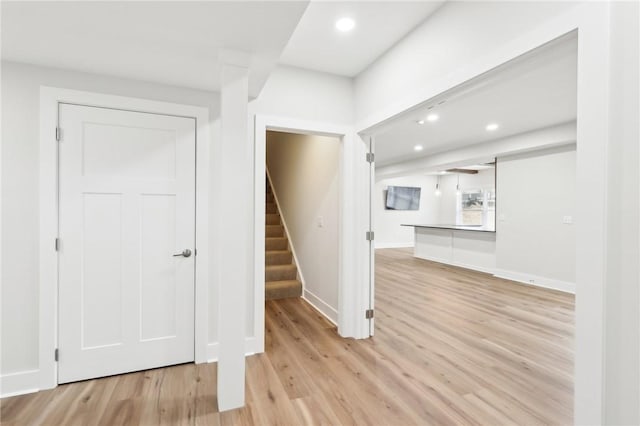 foyer entrance featuring light wood-type flooring, recessed lighting, stairway, and baseboards