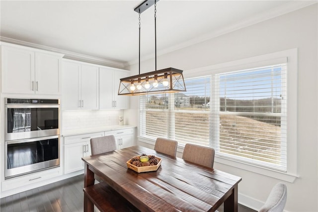 dining area featuring crown molding, dark wood finished floors, and baseboards