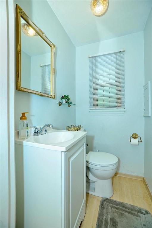 338 Elizabeth Ave, Chalfant Boro, PA 15112 - half bathroom with wood finished floors, toilet, vanity, and baseboards