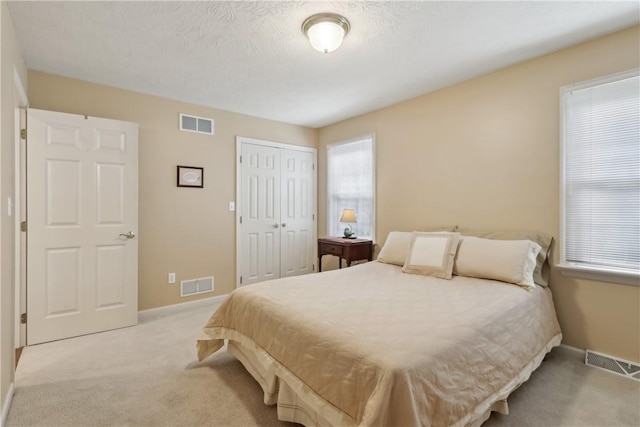 bedroom featuring light colored carpet, baseboards, and a closet