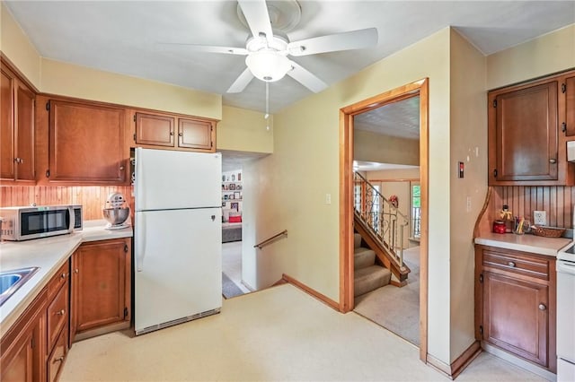 1807 Memorial, Farrell, PA 16121 - kitchen with white appliances, a ceiling fan, light countertops, brown cabinets, and light carpet