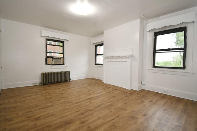 21 Hillson Ave, Brentwood, PA 15227 - unfurnished living room with radiator heating unit, wood finished floors, cooling unit, and healthy amount of natural light