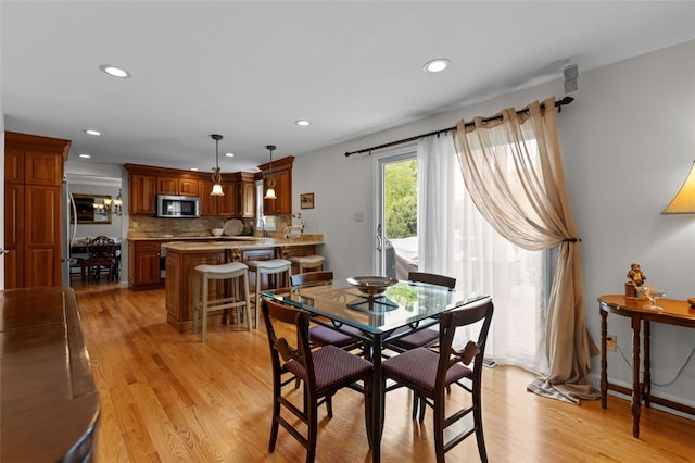 dining room with light wood-style flooring and recessed lighting
