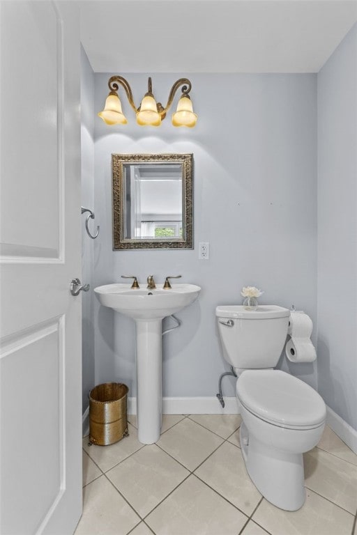 bathroom with toilet, baseboards, and tile patterned floors
