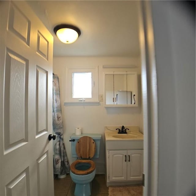 full bath featuring toilet, vanity, and tile patterned floors