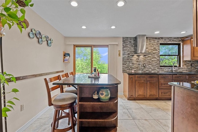 2880 Willowick Ct, South Fayette, PA 15017 - kitchen featuring wall chimney range hood, dark countertops, a sink, decorative backsplash, and plenty of natural light