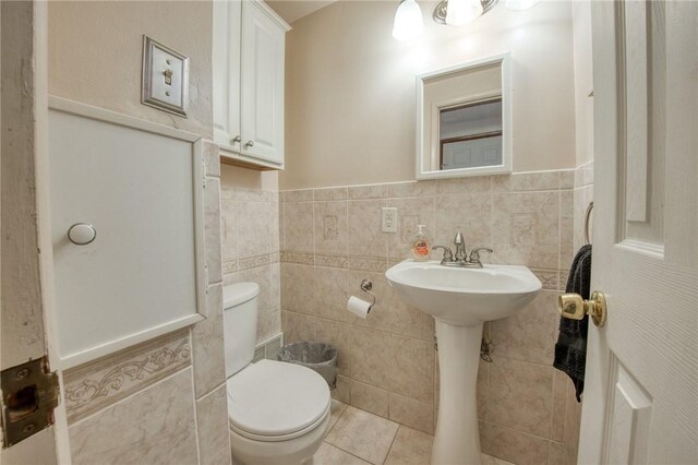 433 Brunner Dr, Monroeville, PA 15146 - half bathroom featuring tile walls, toilet, a wainscoted wall, and tile patterned flooring