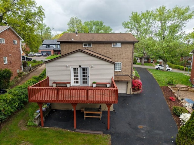 433 Brunner Dr, Monroeville, PA 15146 - rear view of house featuring a wooden deck, french doors, driveway, brick siding, and an attached garage