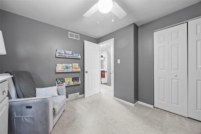 sitting room with ceiling fan, carpet, and baseboards