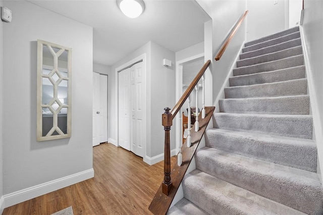 stairs featuring wood finished floors and baseboards