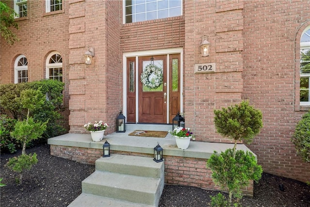 view of exterior entry with brick siding
