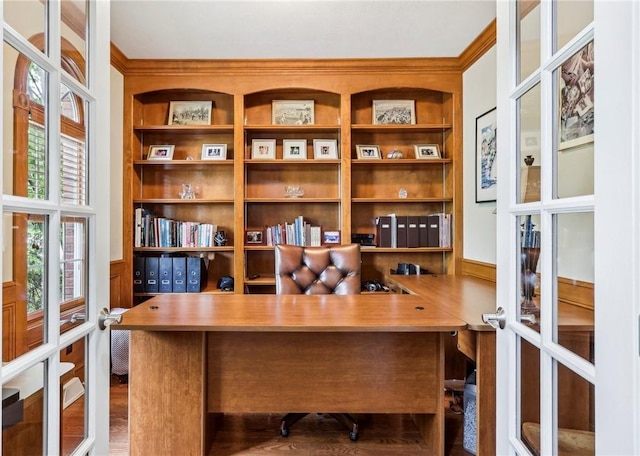 home office with built in features, ornamental molding, french doors, and wood finished floors
