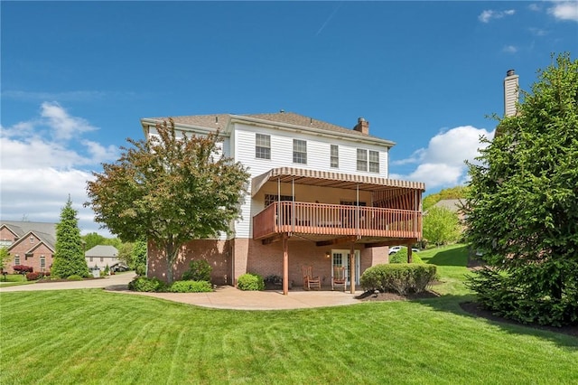 rear view of property featuring a patio area, a lawn, and a wooden deck