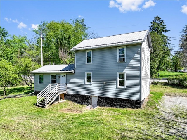 back of property with metal roof and a lawn