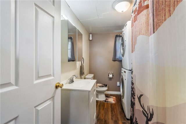 bathroom with stacked washer and clothes dryer, toilet, wood finished floors, vanity, and a shower with curtain
