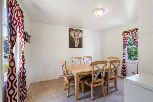 dining area with light colored carpet and baseboards
