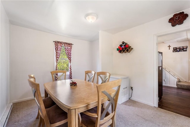 carpeted dining room featuring a baseboard heating unit, baseboards, and stairs