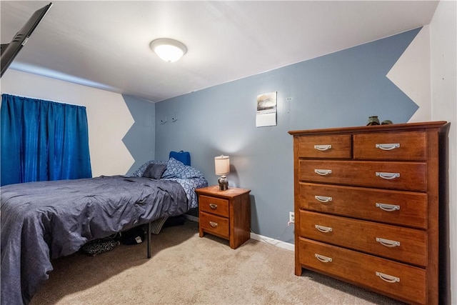 bedroom with light carpet and baseboards
