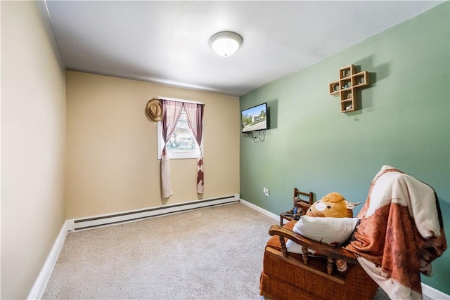 sitting room with a baseboard heating unit, baseboards, and carpet