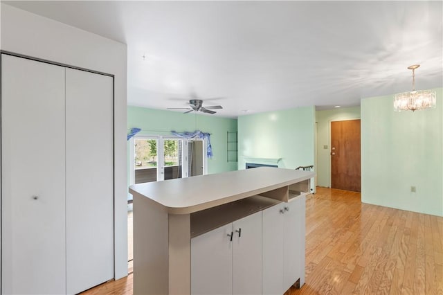 2409 Kenzie Dr, Robinson Twp Nwa, PA 15205 - kitchen featuring light countertops, light wood-style floors, a fireplace, open floor plan, and decorative light fixtures