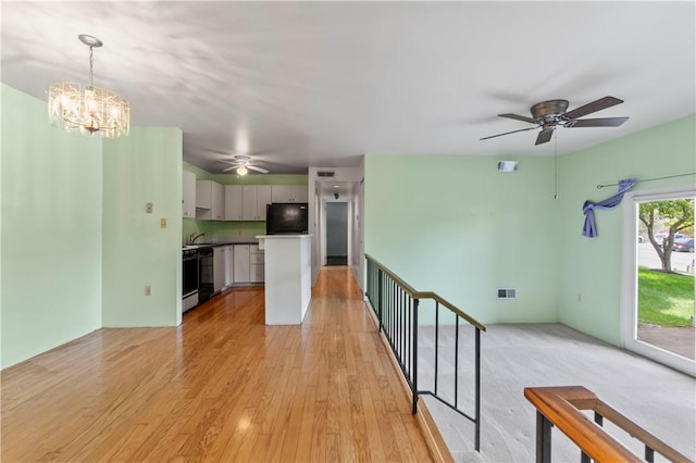 2409 Kenzie Dr, Robinson Twp Nwa, PA 15205 - unfurnished living room featuring a ceiling fan, a chandelier, and light wood-style floors