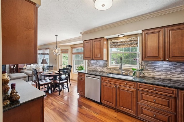 kitchen with dishwasher, a sink, ornamental molding, a textured ceiling, and a chandelier