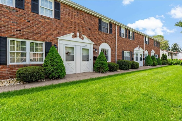 view of front of property featuring a front yard and brick siding