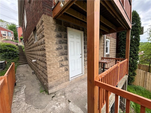 property entrance with fence and stone siding
