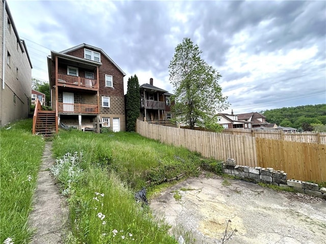 view of yard featuring fence and stairway
