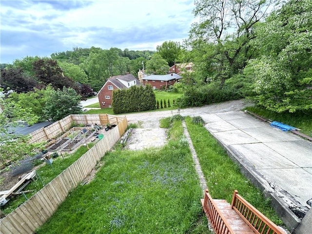 view of grassy yard featuring a vegetable garden