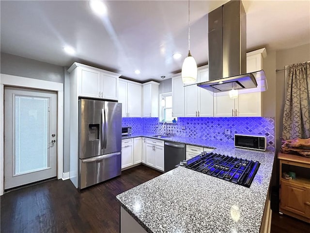 kitchen with appliances with stainless steel finishes, white cabinets, island range hood, decorative backsplash, and recessed lighting