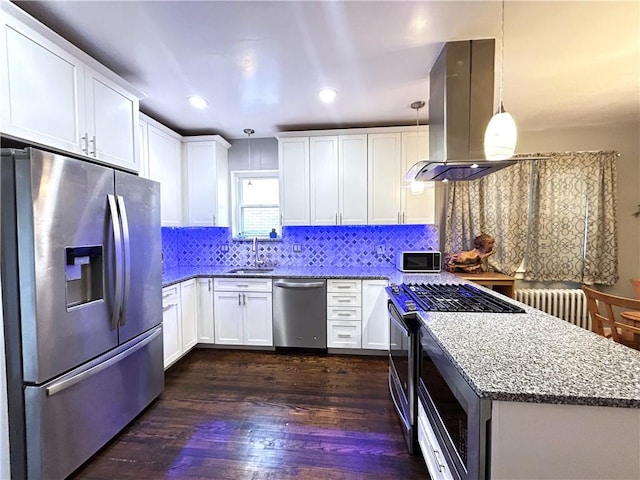 kitchen featuring appliances with stainless steel finishes, island exhaust hood, radiator, a sink, and stone countertops