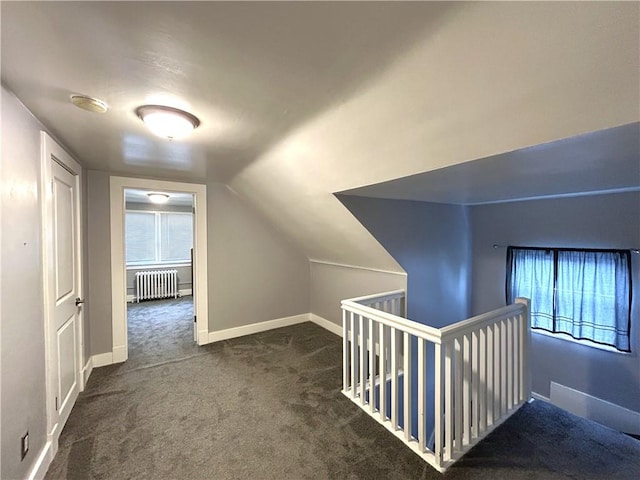 corridor featuring radiator, an upstairs landing, carpet flooring, vaulted ceiling, and plenty of natural light