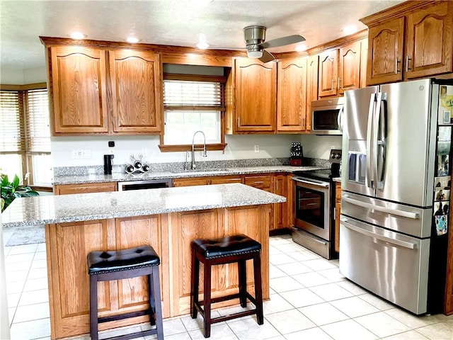112 Pheasant Ridge Dr, Center Twp But, PA 16001 - kitchen featuring stainless steel appliances, a sink, ceiling fan, a breakfast bar, and light stone countertops
