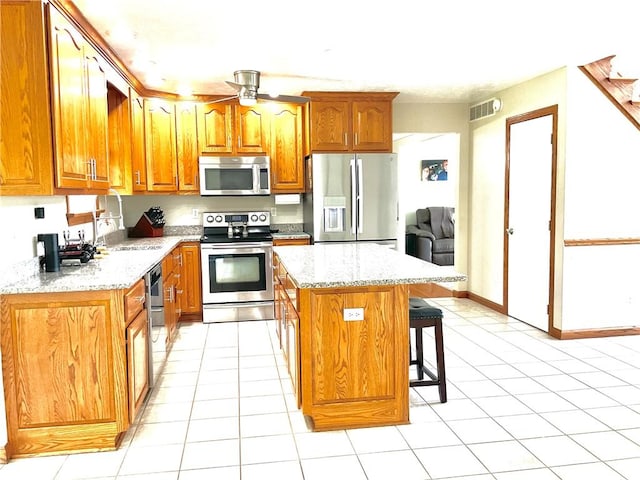 112 Pheasant Ridge Dr, Center Twp But, PA 16001 - kitchen with stainless steel appliances, a sink, ceiling fan, a center island, and a kitchen breakfast bar