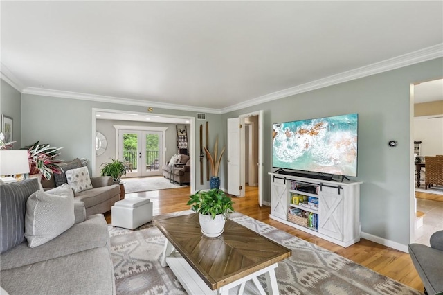 living room featuring crown molding, light wood-style floors, french doors, and baseboards
