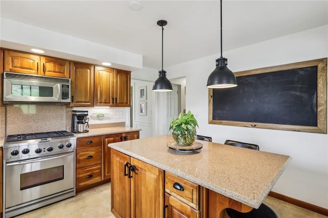 kitchen featuring stainless steel appliances, a center island, tasteful backsplash, light stone countertops, and hanging light fixtures