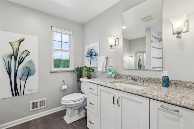 bathroom featuring baseboards, toilet, a shower, vanity, and wood finished floors