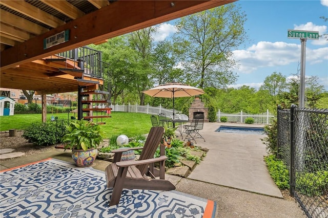 view of patio / terrace featuring an outdoor stone fireplace and stairway