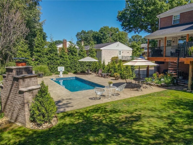 swimming pool with a lawn and a patio area