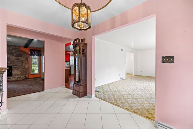 unfurnished room with light carpet, a chandelier, a baseboard radiator, and light tile patterned floors