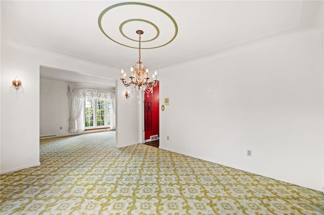 carpeted empty room with a chandelier and baseboards