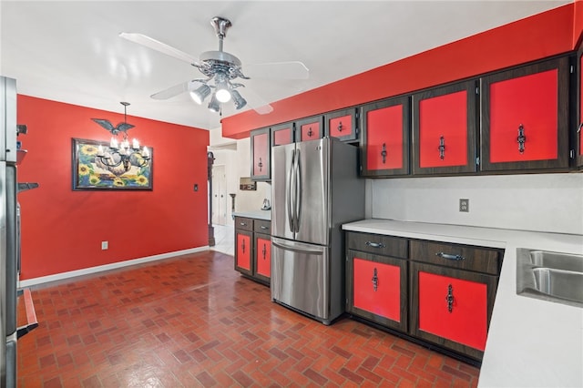 kitchen with freestanding refrigerator, light countertops, a ceiling fan, and brick patterned flooring
