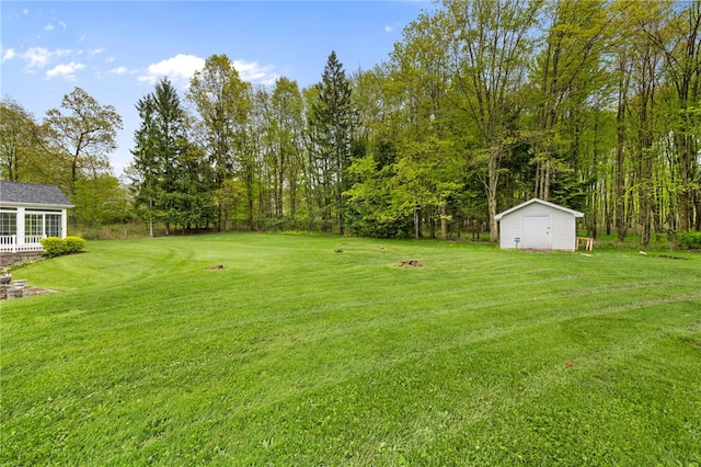 view of green lawn with an outbuilding and a shed